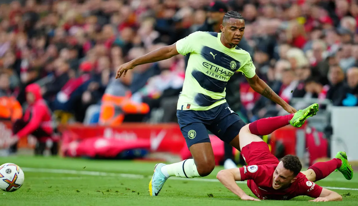 Pemain Manchester City, Manuel Akanji (kiri) memperebutkan bola dengan pemain Liverpool Andrew Robertson dalam pertandingan sepak bola Liga Inggris antara Liverpool dan Manchester City di Stadion Anfield, Liverpool, Minggu (16/10/2022). (AP Photo/Jon Super)