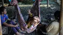 Seorang anak menunggui ibunya yang bekerja mengupas kerang hijau di kawasan Muara Angke, Jakarta, Senin (3/8/2015). Dengan penghasilan Rp 30 ribu/hari, para buruh tersebut harus cukup memenuhi kebutuhan hidup keluarganya. (Liputan6.com/Faizal Fanani)