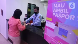Petugas melayani warga yang membuat paspor Republik Indonesia (RI) di Kantor Imigrasi Kelas 1 Non TPI Jakarta Timur, Jakarta, Jumat (14/10/2022). Sesuai Peraturan Menteri Hukum dan HAM RI Nomor 18/2022 mulai 12 Oktober 2022 masa berlaku paspor biasa paling lama 10 tahun untuk semua jenis permohonan yang telah berusia 17 tahun atau sudah menikah. (Liputan6.com/Johan Tallo)