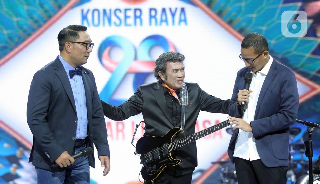 Penyanyi dangdut Rhoma Irama (tengah) berbincang bersama Menteri Pariwisata dan Ekonomi Kreatif Sandiaga Uno (kanan) dan Gubernur Jawa Barat Ridwal Kamil (kiri) pada acara HUT ke-28 Indosiar di Studio 6 EMTEK City, Jakarta, Rabu (11/1/2023). Rhoma Irama membawakan lagu berjudul "Butter" dari BTS dan duet bareng Sandiaga Uno serta Ridwan Kamil saat membawakan lagu berjudul "275 Juta". (Fimela.com/Bambang E. Ros)