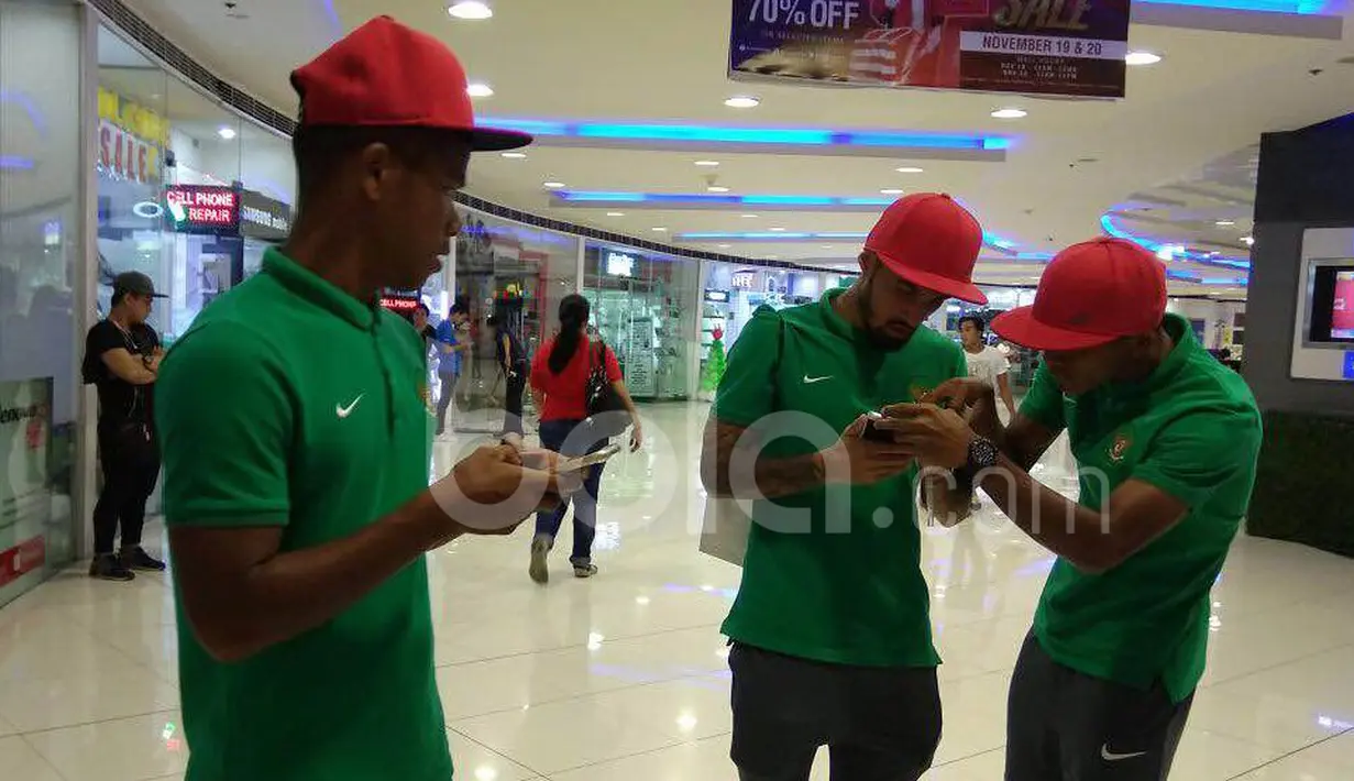 Pemain Timnas Indonesia, Stefano Lilipaly (tengah) ditemani M. Abduh Lestaluhu (kanan) dan Manahati Lestusen (kiri) berkeliling dalam pusat perbelanjaan di Makati City, Manila, Filipina, Minggu (20/11/2016). (Bola.com/Nicklas Hanoatubun)