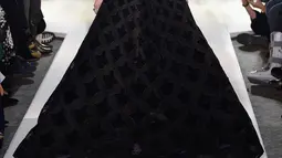 Model Bella Hadid mengenakan gaun hitam koleksi terbaru dari Oscar de la Renta berjalan di atas catwalk selama New York Fashion Week, AS (12/2). Gaun yang dikenakan Bella Hadid dihiasi motif simetris. (AFP Photo/Slaven Vlasic)