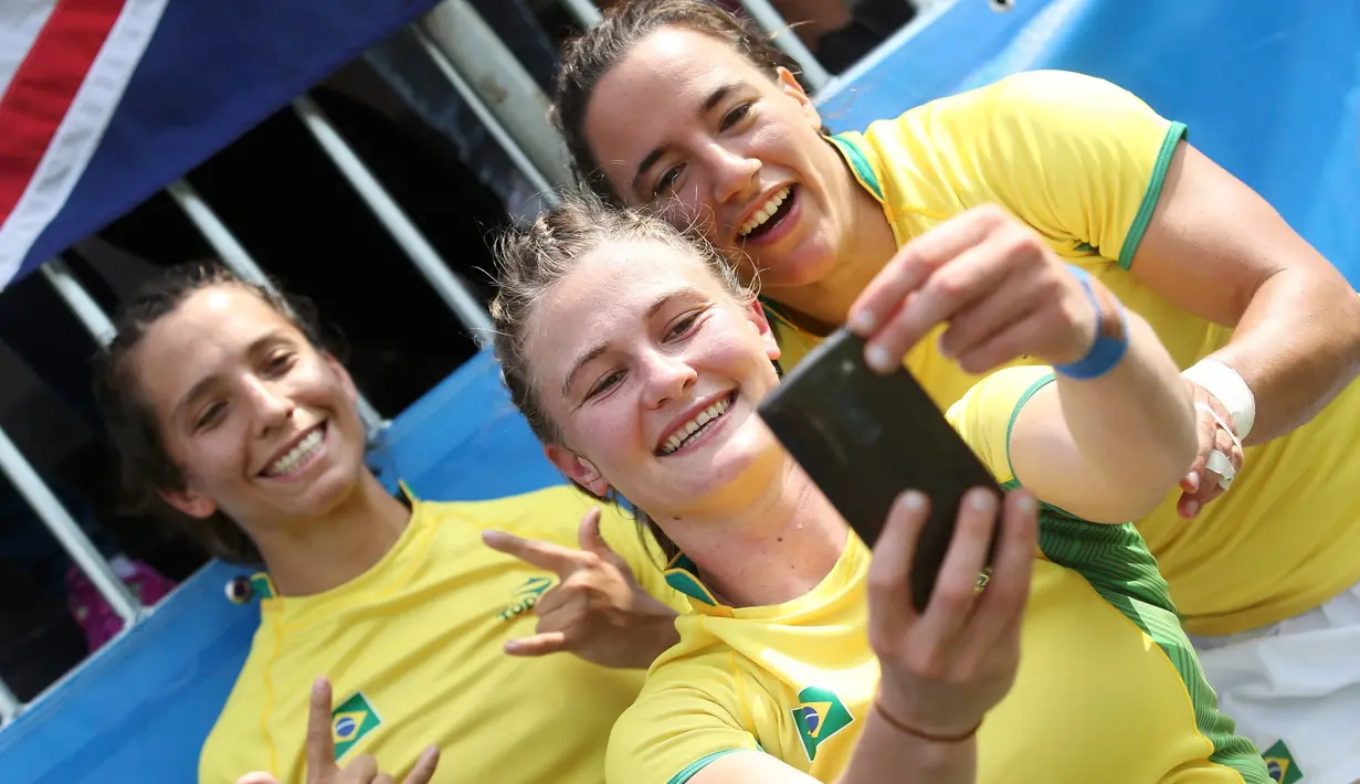 Atlet Rugby asal Brasil, Isadora Cerullo (kanan) foto bersama dengan rekannya setelah pertandingan rugby di Stadium Deodoro, Rio de Janeiro, Brasil, (8/8). (REUTERS/Alessandro Bianchi)