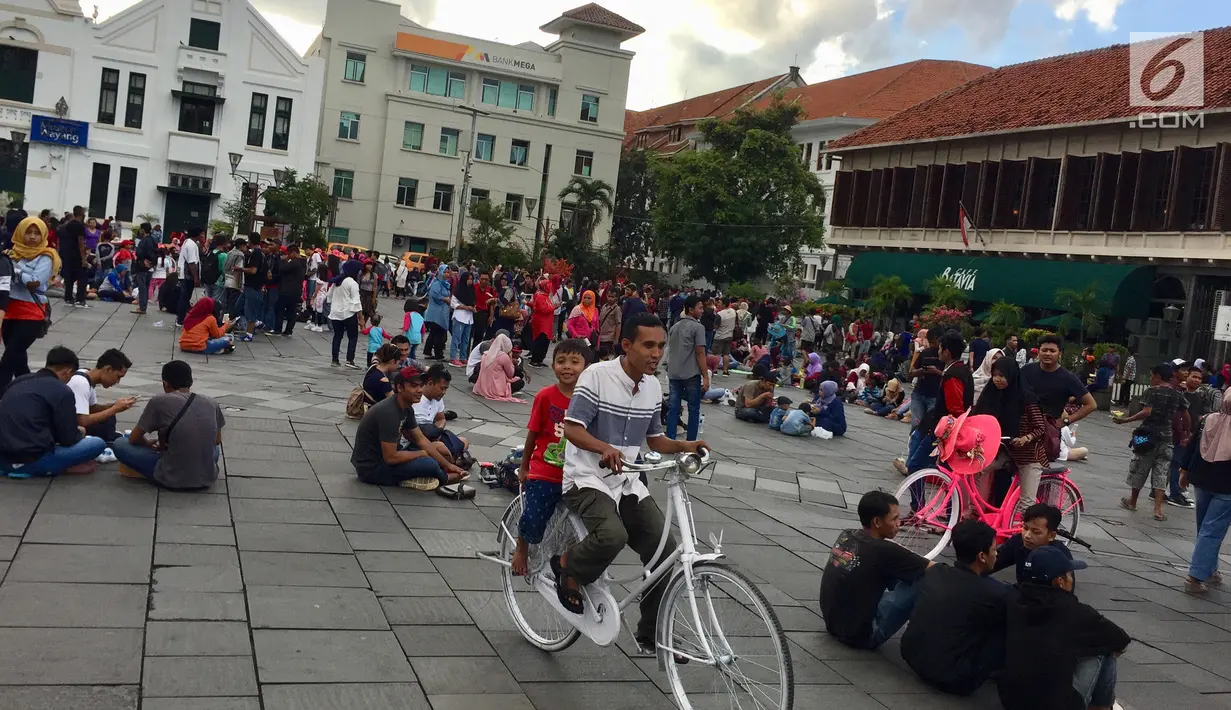 Pengunjung bersepeda mengelilingi kawasan Kota Tua, Jakarta, Jumat (16/2). Wisata Kota Tua menjadi salah satu alternatif favorit warga libur Tahun baru Imlek 2018 selain murah juga memiliki nilai edukatif dan historis. (Liputan6.com/Immanuel Antonius)