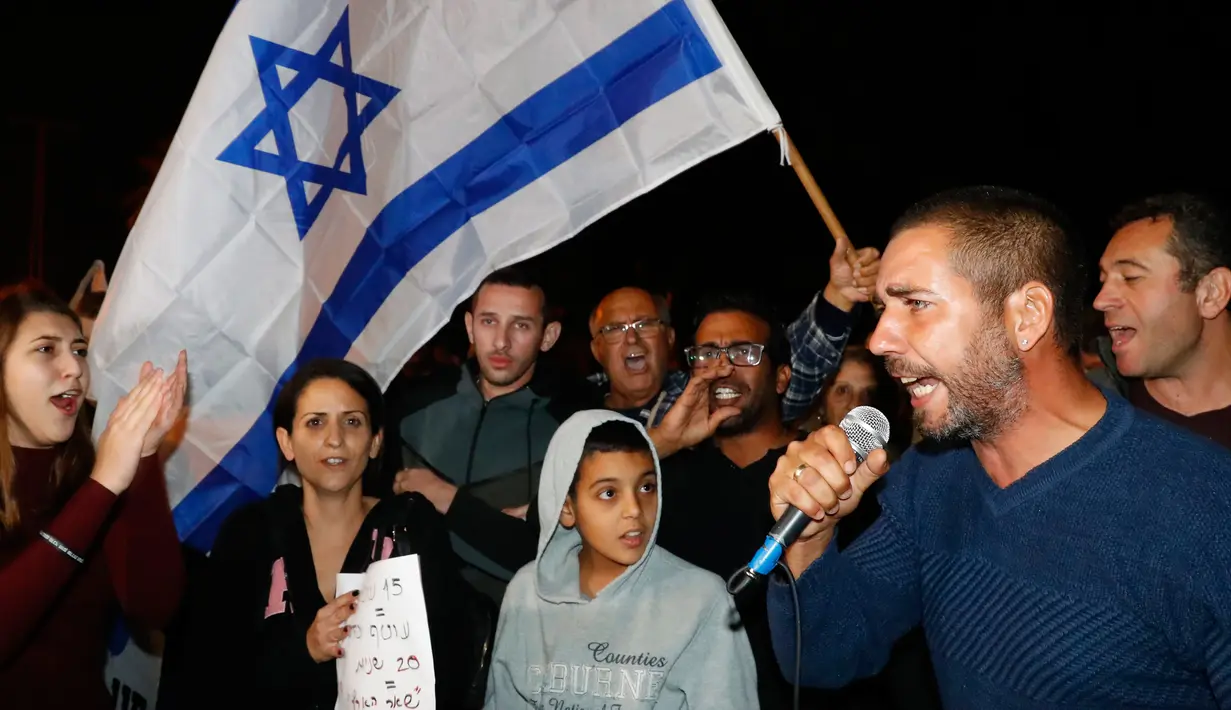 Warga berdemonstrasi menentang gencatan senjata dengan Hamas di Kota Ashkelon Selatan, Israel, Rabu (14/11). Sebelumnya, militer Israel dan Hamas sering adu serangan roket dan udara selama berbulan-bulan. (JACK GUEZ/AFP)
