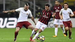 Gelandang AC Milan, Hakan Calhanoglu, berebut bola dengan gelandang AS Roma, Radja Nainggolan, pada laga Serie A Italia di Stadion San Siro, Milan, Minggu (1/10/2017). Milan kalah 0-2 dari Roma. (AFP/Miguel Medina)