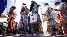 Perempuan Jepang berkimono yang merayakan ulang tahun ke-20 antre memasuki tempat untuk berpartisipasi dalam upacara resmi, yang biasa disebut upacara Kedewasaan di Yokohama dekat Tokyo, Senin (9/1/2023). Diadakan setiap tahun pada hari Senin kedua di bulan Januari, pemerintah kota setempat merayakan Hari Kedewasaan atau Seiji no Hi. (AP Photo/Eugene Hoshiko)