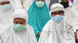 Umat muslim mengenakan masker sambil salat minta hujan (Istisqa)  ketika kabut asap menyelimuti kota Pekanbaru, di Riau, Jumat (13/9/2019). Kegiatan ini untuk meminta turunnya hujan guna mengurangi dampak kabut asap kebakaran hutan dan lahan di sejumlah wilayah di Provinsi Riau. (ADEK BERRY/AFP)