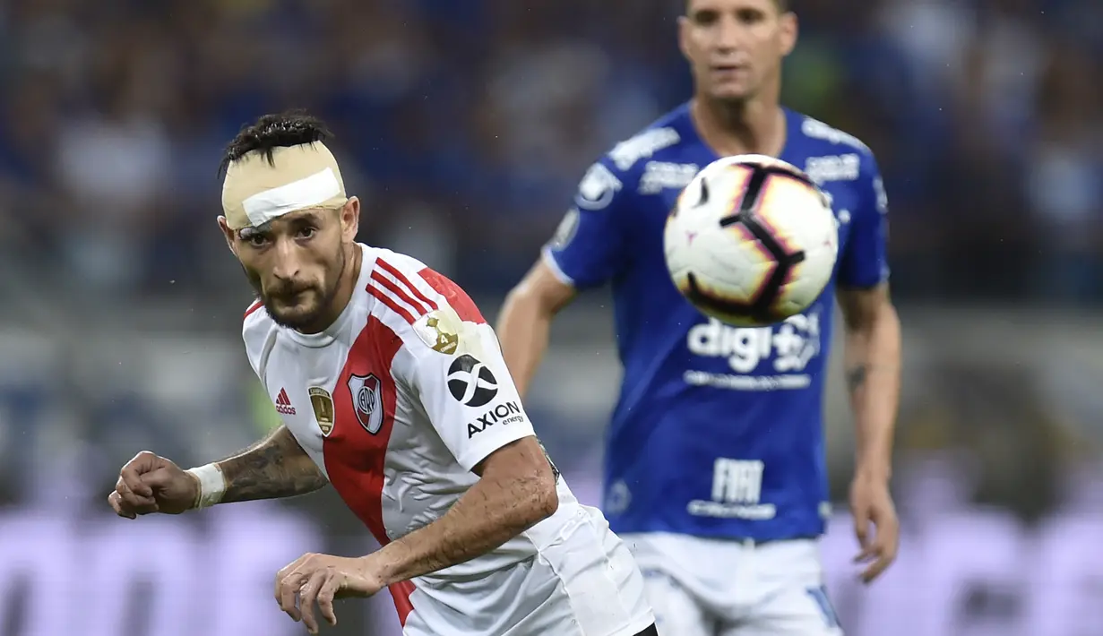 Pemain River Plate, Milton Casco, berebut bola dengan pemain Cruzeiro, Thiago Neves, pada laga Copa Libertadores di Stadion Mineirao, Belo Horizonte, Selasa (30/7). River Plate lolos ke babak perempat final. (AFP/Douglas Magno)