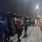 Kerumunan warga menyaksikan pencarian pengamen yang melompat ke Kali Ancol, Jakarta Utara, Minggu (31/7/2017). (Liputan6.com/Moch Harun Syah)