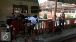 Peserta mengerjakan soal Ujian Paket B di SMP Muhammadiah Klaten,Yogyakarta (11/5). Ujian tersebut untuk mendapatkan ijazah setingkat SMP diikuti oleh 111 peserta. (Liputan6.com/Boy Harjanto)