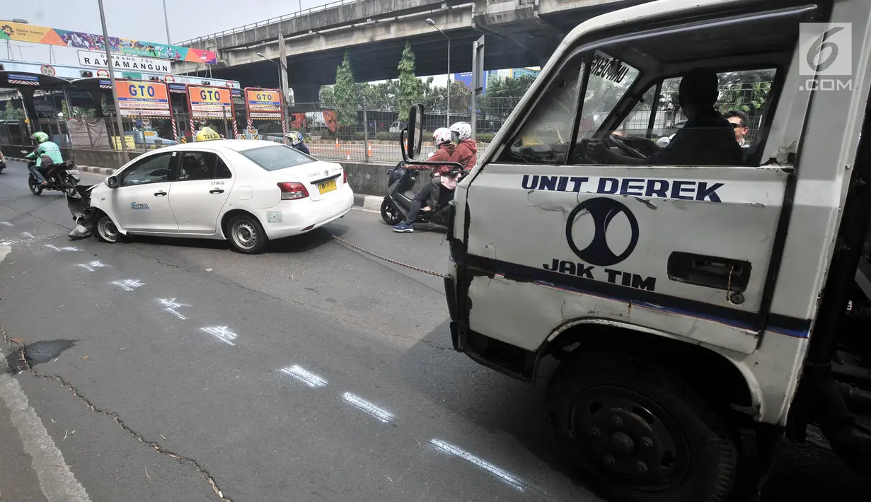 Petugas derek mengevakuasi mobil taksi usai kecelakaan tunggal di Jalan Ahmad Yani, Jakarta, Rabu (1/8). (Merdeka.com/Iqbal Nugroho)