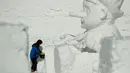 Seorang seniman mengukir patung es raksasa di Snow Land, PyeongChang, Korea Selatan, Minggu (4/2). Hal ini dilakukan untuk menyambut Olimpiade Musim Dingin PyeongChang 2018. (AP Photo/Charlie Riedel)