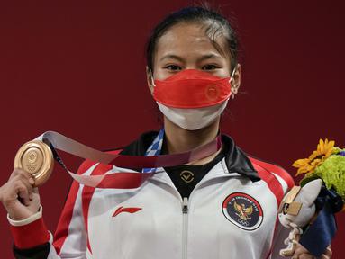 Windy Cantika Aisah yang turun di nomor 49kg putri cabang olahraga angkat besi berhasil meraih medali perunggu serta medali pertama bagi Indonesia lewat total angkatan 194 kg. (Foto: AP/Luca Bruno)