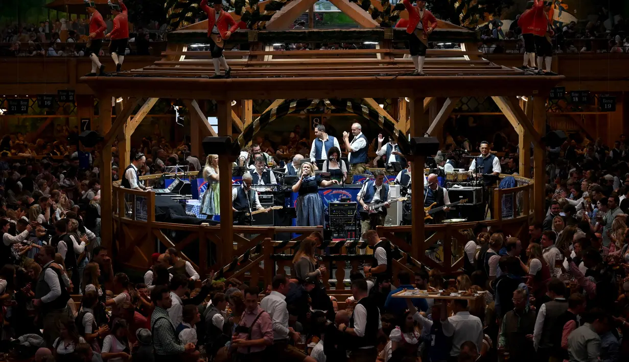 Sebuah band musik tampil sementara pengunjung festival merayakan di tenda bir selama festival bir Oktoberfest di arena pameran Theresienwiese di Munich, Jerman selatan (20/9/2022). Festival Bir yang terkenal di dunia ini akan berlangsung hingga 3 Oktober 2022 tanpa batasan akses, setelah dua hari terakhir edisi tahun telah dibatalkan karena pandemi coronavirus. (AFP/Christof Stache)