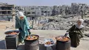 Di tengah krisis kelaparan yang terus mengancam kehidupan di Gaza, kakak beradik Palestina, Lina Zeid dan Aya Zeid, menyalurkan bantuan berupa paket makanan gratis kepada anak-anak pengungsi di daerah Al-Tuam, sebelah barat Jabalia, Jalur Gaza Utara. Tampak dalam foto, kakak beradik Palestina, Lina Zeid (kiri) dan Aya Zeid, menyiapkan makanan di atap rumah mereka untuk dibagikan kepada anak-anak pengungsi sebagai kegiatan amal di daerah Al-Tuam, sebelah barat Jabalia, Jalur Gaza Utara pada Rabu 6 Mei 2026. (Omar AL-QATTAA/AFP)