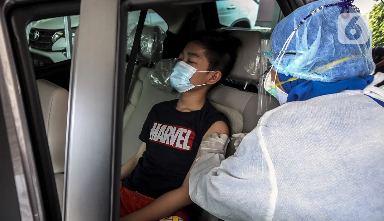 Warga menerima vaksinasi COVID-19 secara drive-thru di Jalan Duri Raya, Jakarta Barat, Kamis (8/7/2021). Yayasan Cinta anak Bangsa (YACB) Fondation menggelar vaksinasi COVID-19 secara drive-thru dengan menargetkan 800 hingga 1.000 warga ikut vaksinasi ini. (Liputan6.com/Johan Tallo)