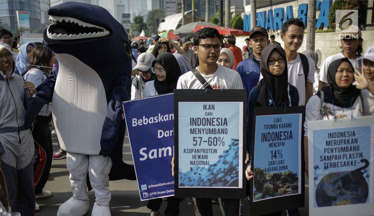 Sejumlah mahasiswa memampang poster yang berisi informasi data saat menggelar aksi kampanye tentang kehidupan biota laut saat Car Free Day di Kawasan Bunderan HI, Jakarta, Minggu (4/3). (Liputan6.com/Faizal Fanani)