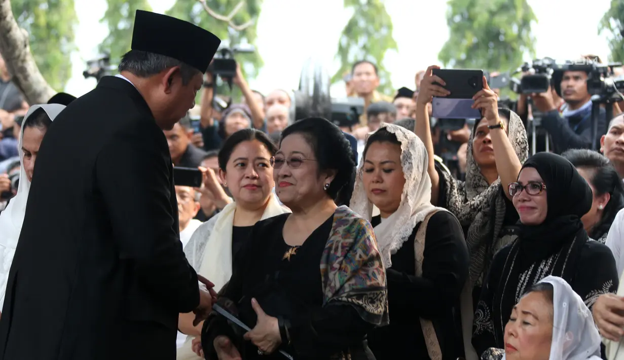 Presiden ke-6 RI Susilo Bambang Yudhoyono bersalaman dengan Presiden ke-5 RI Megawati Soekarnoputri usai prosesi pemakaman Ani Yudhoyono di TMP Kalibata, Jakarta, Minggu (2/6/2019). Megawati tampak melempar senyum kepada SBY disamping Sinta Nuriyah Wahid. (Liputan6.com/HO/Rangga)