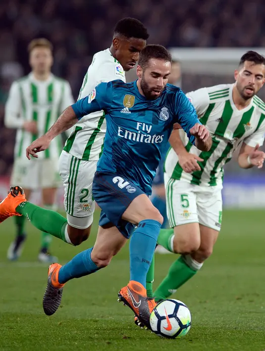 Bek Real Madrid, Dani Carvajal berebut bola dengan pemain Real Betis, Jordi Amat pada laga pekan ke-24 La Liga Spanyol, di Estadio Benito Villamarin, Minggu (18/2). Real Madrid menang dengan skor 5-3. (Cristina Quicler/AFP)