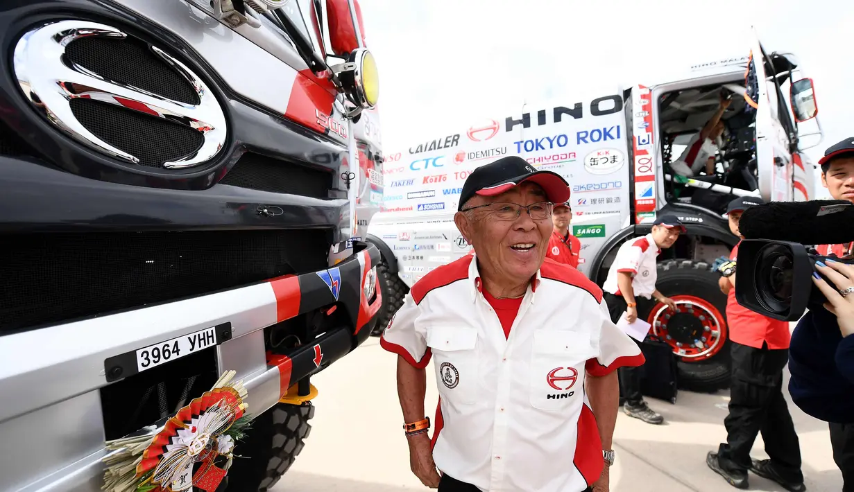 Pembalap Hino Yoshimasa Sugawara dari Jepang tersenyum selama pemeriksaan teknis jelang Reli Dakar 2018 di Lima, Peru (3/1). Yoshimasa Sugawara merupakan pembalap kawakan berusia 76 tahun yang ikut Reli Dakar 2018. (AFP Photo/Franck Fife)