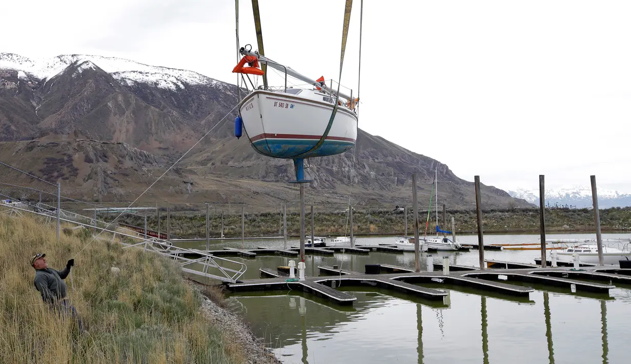 Pekerja menarik perahu layar untuk dipindahkan ke Great Salt Lake, Utah (6/4). Setelah badai musim dingin menaikan tingkat air danau perahu layar ini akan beroperasi kembali. (AP Photo / Rick Bowmer)