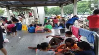 Sejumlah Warga yang Rumahnya Terendam Banjir Terpaksa Mengungsi di Halte Jembatan Baru Cengkareng, Rabu (1/1/2020). (Foto: Delvira Hutabarat/Liputan6.com)