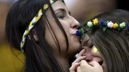 Suporter Timnas Brasil berpelukan menahan kesedihan menyaksikan kegagalan tim asuhan Luiz Felipe Scolari dikalahkan Belanda 0-3 di Stadion Nasional Brasilia, (13/7/2014). (REUTERS/Ueslei Marcelino)