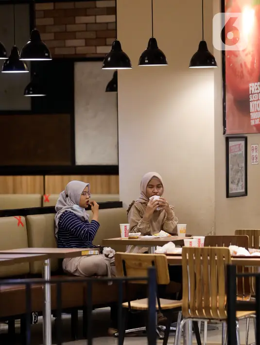 Pengunjung menyantap makanan di restoran yang berada di Mal Central Park, Jakarta, Jumat (20/8/2021). Restoran dalam pusat perbelanjaan kini bisa makan di tempat dengan syarat kapasitas maksimal 25 persen, satu meja maksimal dua orang, dan waktu makan maksimal 30 menit. (Liputan6.com/Angga Yuniar)