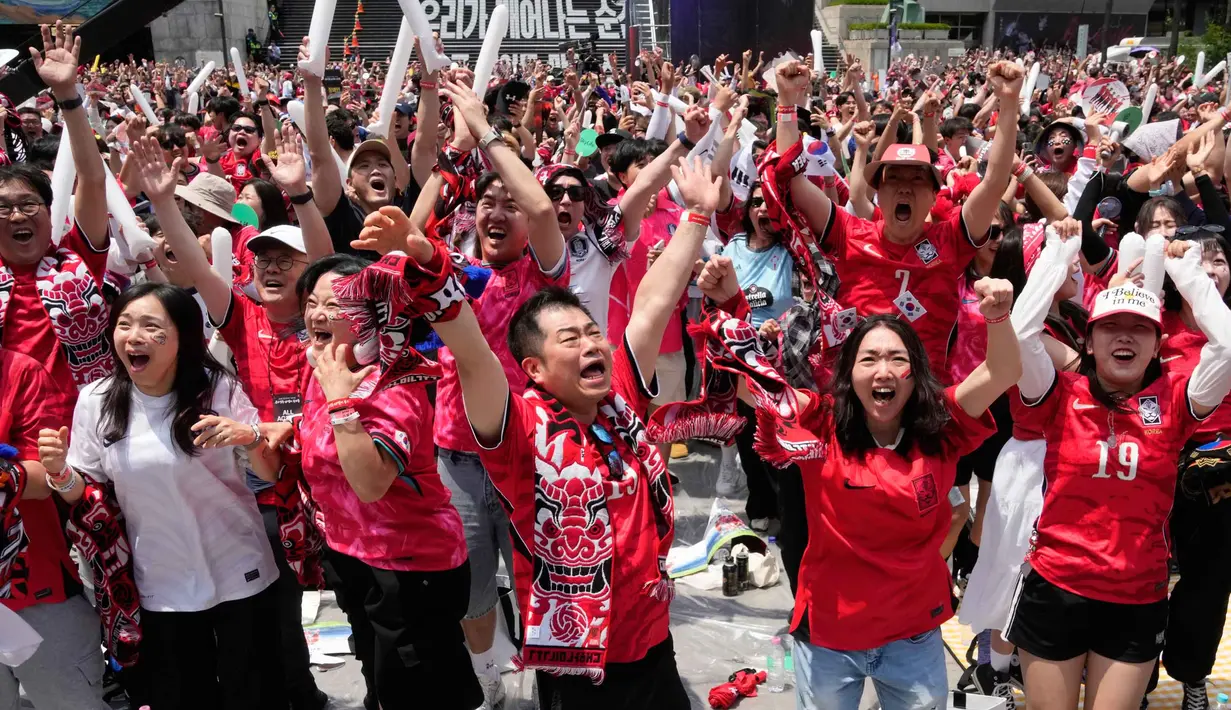 Penggemar sepak bola merayakan gol pertama yang dicetak Timnas Korea Selatan ke gawang Republik Ceko pada pertandingan sepak bola Grup A Piala Dunia 2026, di tempat penonton umum di Seoul, Korea Selatan, Jumat 12 Juni 2026. (AP Photo/Ahn Young-joon)