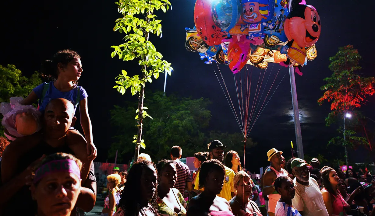 Penonton menyaksikan sesi latihan oleh sekolah Mangueira samba di Rio de Janeiro, Brasil (21/2). Karnaval Rio de Janeiro akan berlangsung dari 2 Maret hingga 9 Maret 2019. (AFP Photo/Carl De Souza)