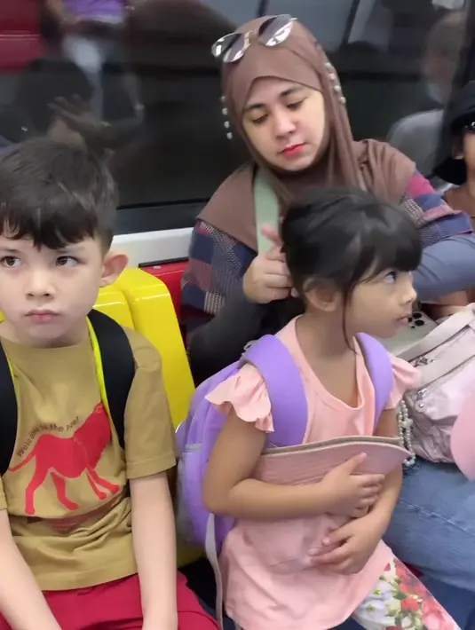 Seperti ini potret ibu tiga anak saat liburan. Siap dengan berbagai barang bawaan tapi tetap cantik. [Instagram @ristytagor]