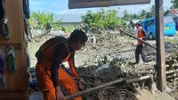 Petugas SAR membantu membersihkan rumah warga pascabanjir bandang di Desa Pohi, Kabupaten Banggai, Kamis (1/9/2022). (Foto: Basarnas Palu).