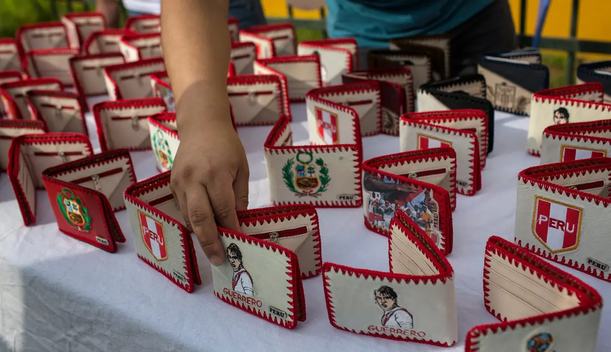Seorang narapidana menampilkan dompet buatan tangan dengan gambar bintang sepak bola Peru Paolo Guerrero di Penjara San Juan de Lurigancho, Lima, Peru, Kamis (24/5). (AP Photo/Rodrigo Abd)