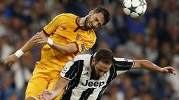 Striker Juventus, Gonzalo Higuain, berebut bola dengan pemain Sevilla, Vicente Iborra, pada laga Liga Champions Grup H di Juventus Stadium, Turin, Kami (15/9/2016) dini hari WIB. (AFP/Marco Bertorello)