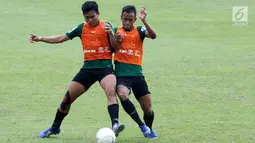 Pemain Timnas Indonesia U-22, Nurhidayat berebut bola dengan Dallen Doke saat berlatih di Stadion Madya, Jakarta, Kamis(24/1). Latihan ini digelar untuk menghadapi Piala AFF U-22. (Bola.com/Yoppy Renato)