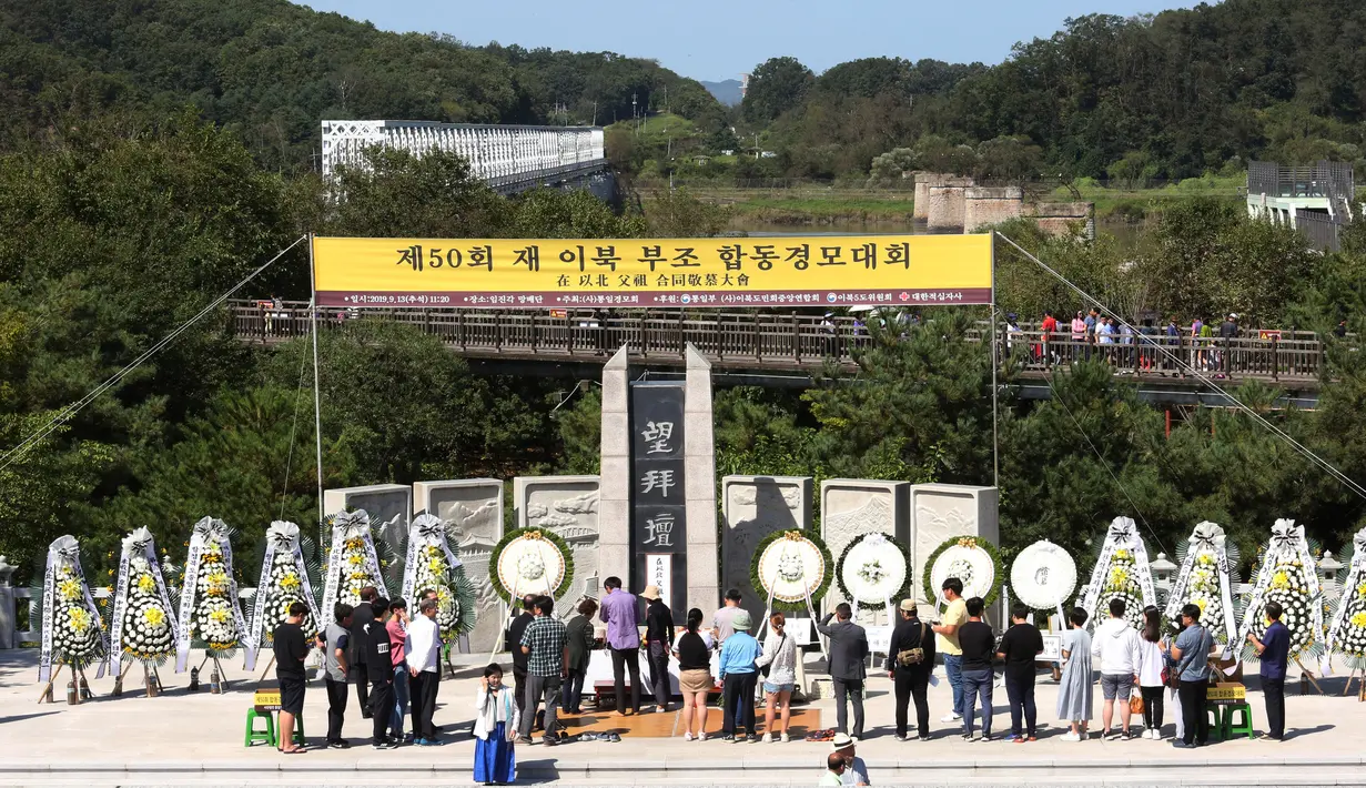 Pengungsi Korea Utara, Kim Jong-ae menyaksikan anggota keluarganya memberikan penghormatan kepada leluhur untuk merayakan Chuseok di Imjingak Pavilion, Paju dekat perbatasan dengan Korea Utara, Jumat (13/9/2019). Chuseok sendiri merupakan Hari Thanksgiving di Korea. (AP/Ahn Young-joon)