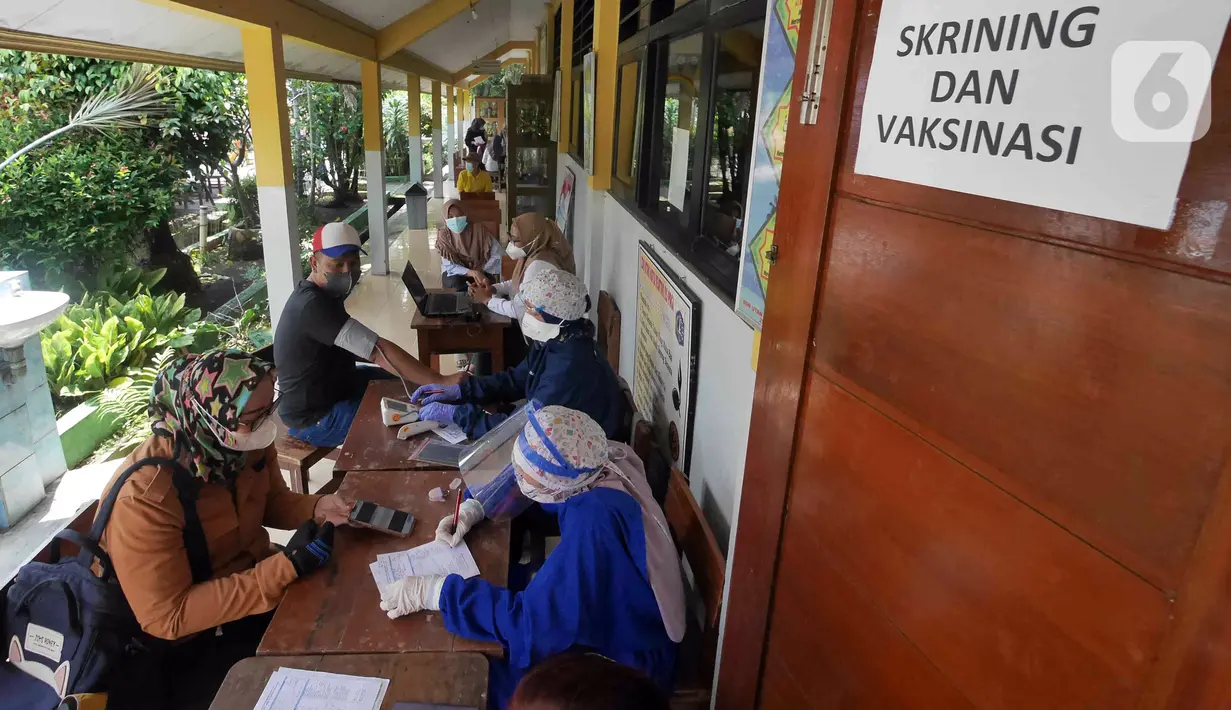 Petugas kesehatan dari Puskesmas Kecamatan Matraman melakukan skrining saat vaksinasi COVID-19 di SD Negeri 25 Utan Kayu Selatan, Matraman, Jakarta Timur, Rabu (23/3/2022). Vaksin yang digunakan adalah vaksin AstraZeneca untuk dosis pertama, kedua dan ketiga (booster). (Liputan6.com/Herman Zakharia)