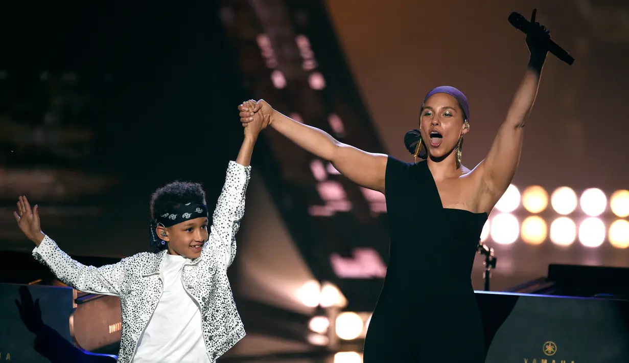 Penyanyi Alicia Keys mengangkat tangan putranya Egypt Dean selama acara iHeartRadio Music Awards 2019 di Los Angeles, California, AS (14/3).  Alicia Keys membawakan lagu Raise a Man dan You Don't Know My Name. (AP Photo/Chris Pizzello)