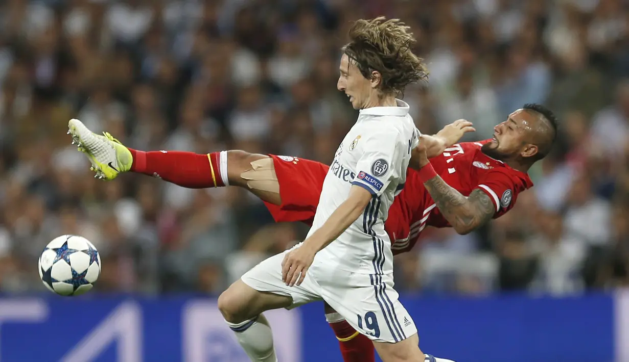 Duel pemain Bayern Munchen, Arturo Vidal (kanan) dan pemain Real Madrid, Luka Modric pada leg kedua perempatfinal Liga Champions di Santiago Bernabeu stadium, Madrid, (18/4/2017). Real Madrid menang 4-2. (AP/Francisco Seco)