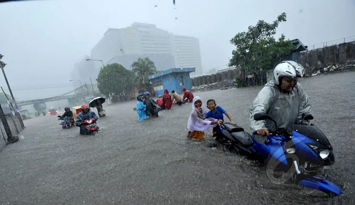 Sejumlah pengendara motor terpaksa mendorong kendaraannya akibat nekat menerobos banjir yang menggenangi jalan Gunung Sahari, Jakarta, Senin (9/2/2015).  (Liputan6.com/Faizal Fanani)