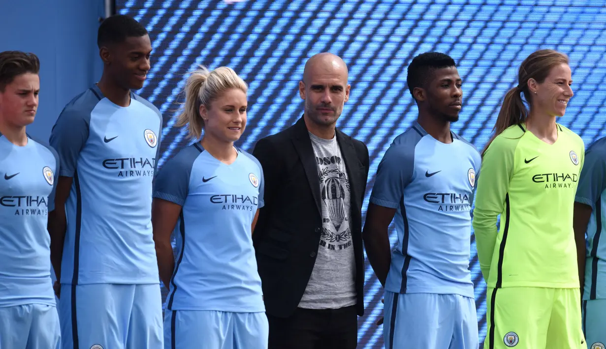 Pelatih Pep Guardiola (tengah) berdiri bersama deretan pemain muda dan pemain wanita Manchester City pada acara perkenalan klub di  City Football Academy, Manchester, (3/7/2016). (AFP/Oli Scarf)