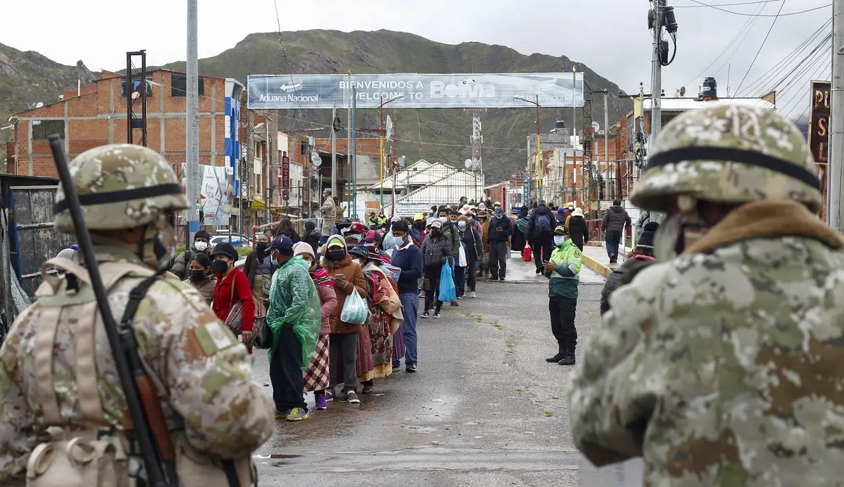 Tentara memeriksa lalu lintas pejalan kaki di perbatasan Peru dengan Bolivia di desa Desaguadero, Peru, pada 18 Februari 2022. Pemerintah Peru membuka kembali perbatasan dengan Bolivia dan Ekuador setelah ditutup hampir dua tahun karena pandemi Covid-19. (Carlos MAMANI/AFP)
