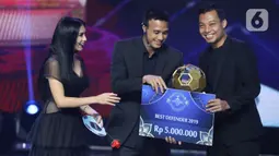 Pemain belakang Arema FC, Hamka Hamzah (kanan) menerima trofi Best Defender 2019 saat Indonesian Soccer Award 2019 di Studio 6 Indosiar, Jakarta, Jumat (10/1/2020). 16 penghargaan diberikan pada acara ini. (Liputan6.com/Helmi Fithriansyah)