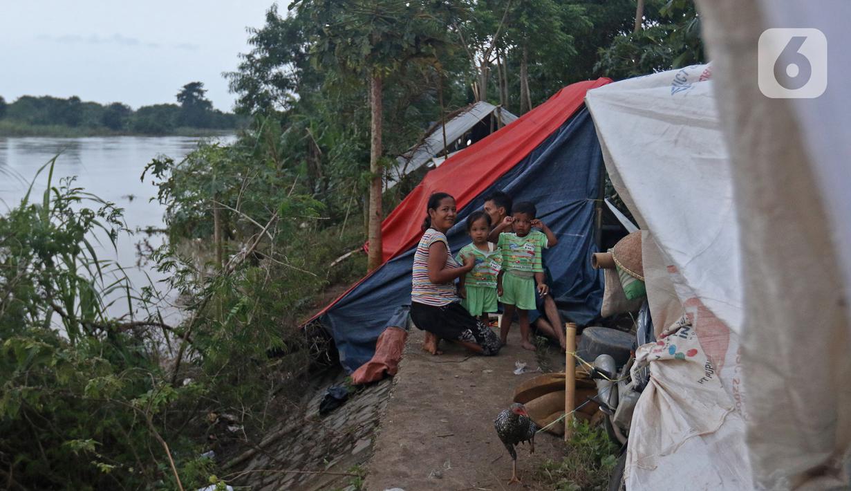 Warga mengungsi di tenda di bantaran sungai Citarum Desa Sumber Urip Pebayuran, Senin (22/2/2021). Sudah tiga hari warga bertahan di tenda pengungsian dikarenakan banjir luapan sungai Citarum yang merendam permukiman warga kampung Babakan Banten Pebayuran. (Liputan6.com/Herman Zakharia)