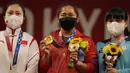 Medali emas di Olimpiade Tokyo diraihnya usai menyingkirkan unggulan dari Cina, Liao Qiuyun, yang akhirnya meraih perak. Hidilyn Diaz total mengangkat barbel seberat 224 kg, unggul 1 kg dari Liao Qiuyun. (Foto: AP/Luca Bruno)