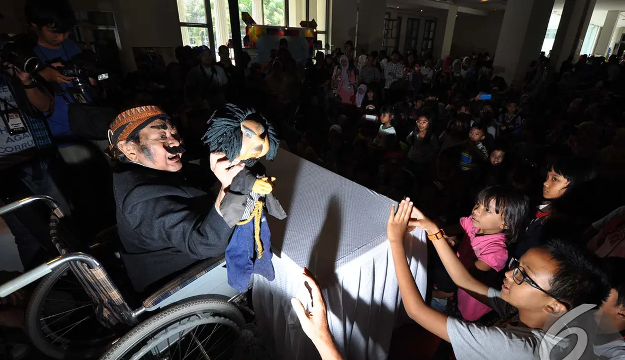 Para bocah yang ikut mendengarkan dongeng dari Pak Raden tidak menyia-nyiakan kesempatan untuk memfoto Pak Raden dari dekat, Jakarta, Minggu (2/11/2014). (Liputan6.com/Miftahul Hayat)