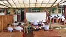Sejumlah murid Sekolah Dasar Negeri (SDN) Mutiara mengikuti aktivitas belajar di dalam tenda darurat di Kampung Pasir Bayur, Cibeber II, Bogor, Selasa (3/4). Kurang lebih sebulan ini murid kelas 1 hingga 5 belajar di luar kelas. (Merdeka.com/Arie Basuki)