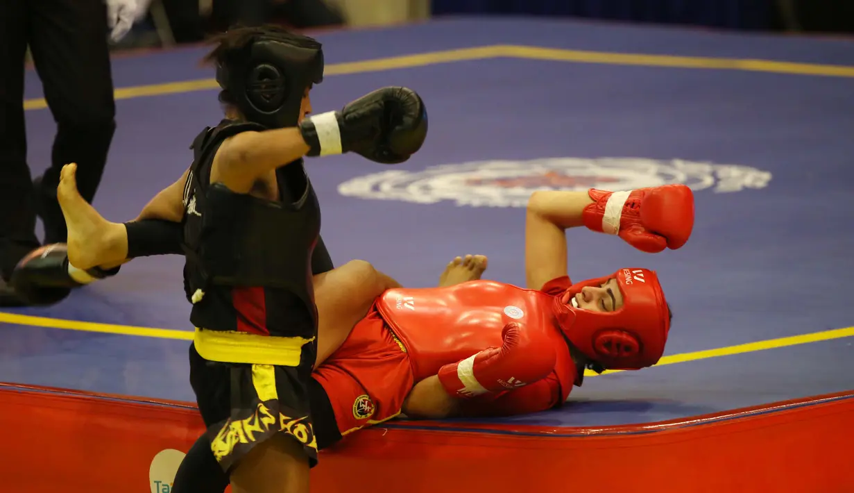 Atlet wushu Indonesia, Moria Manalu (kiri), membanting lawannya asal Turki, Nagihan Kalyoncu di kelas Sanda Wanita 60 kg pada Kejuaraan Dunia Wushu 2015 di Istora Gelora Bung Karno, Senayan, Jakarta, Senin (16/11/2015). (Bola.com/Nicklas Hanoatubun)