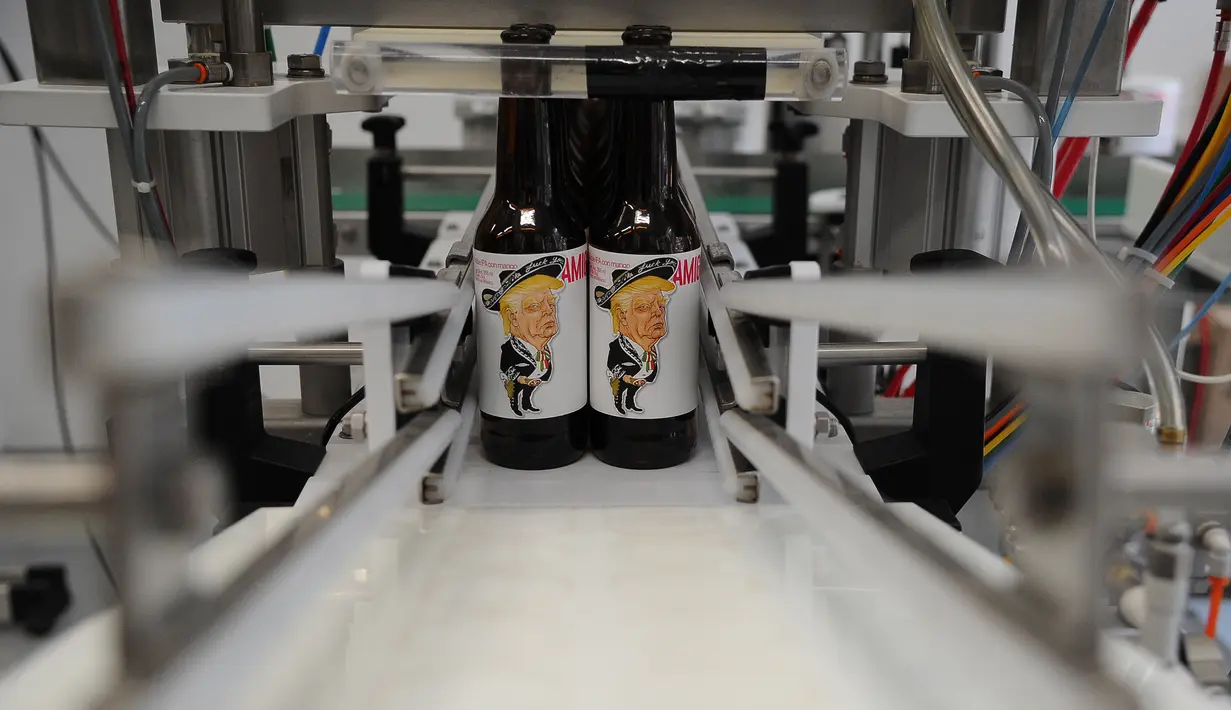 Sejumlah botol bir bergambar Presiden AS, Donald Trump sedang diproses di perusaahan Cru Cru Brewery di Mexico City (15/6). Botol bir ini labelnya bergambar Donald Trump dengan mengenakan pakaian bergaya Mariachi.  (AFP Photo/Bernardo Montoya)